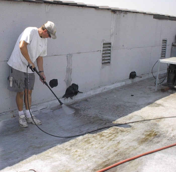 Pressure washing a flat roof surface before waterproofing
